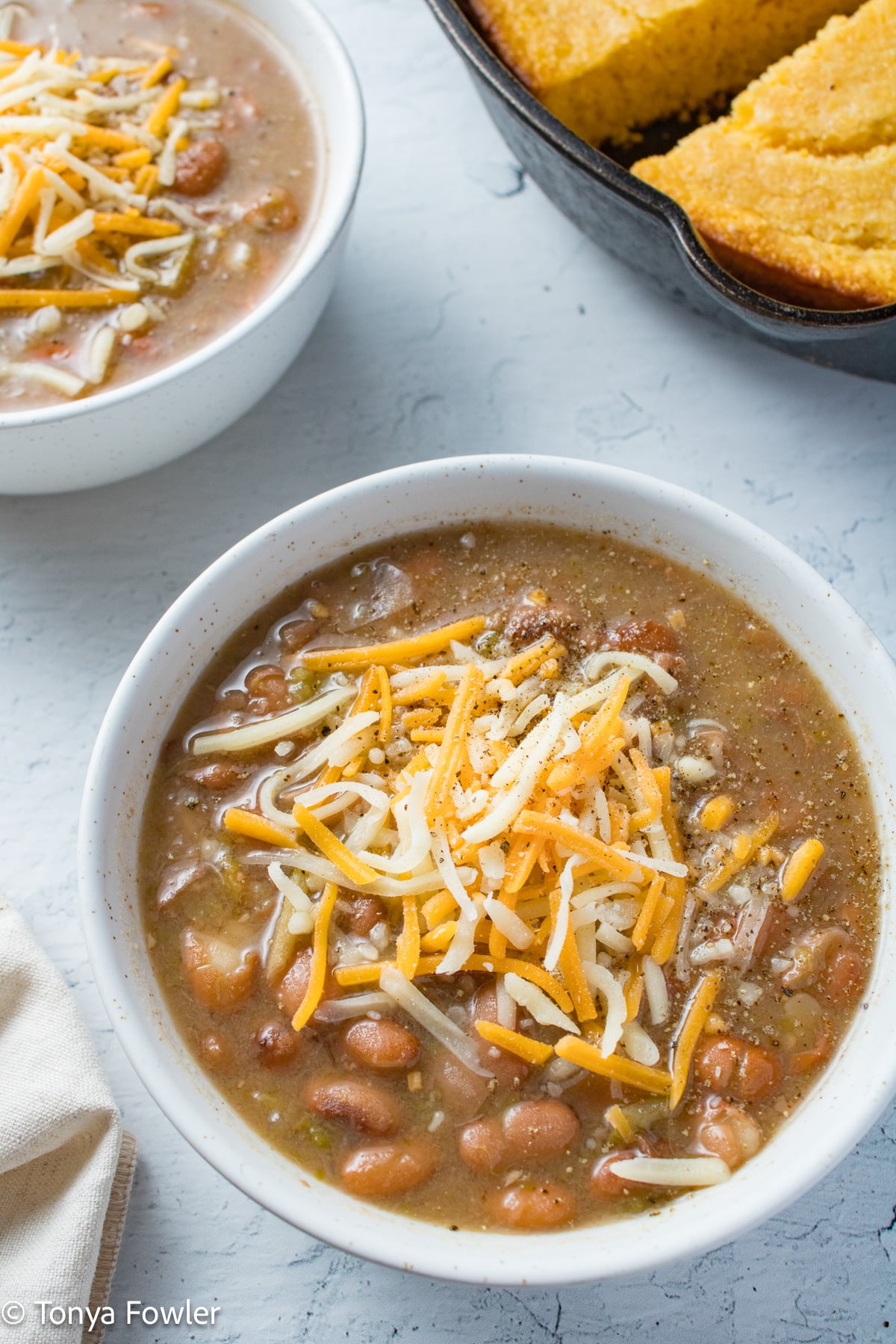 Beans in a bowl with cheese on top.