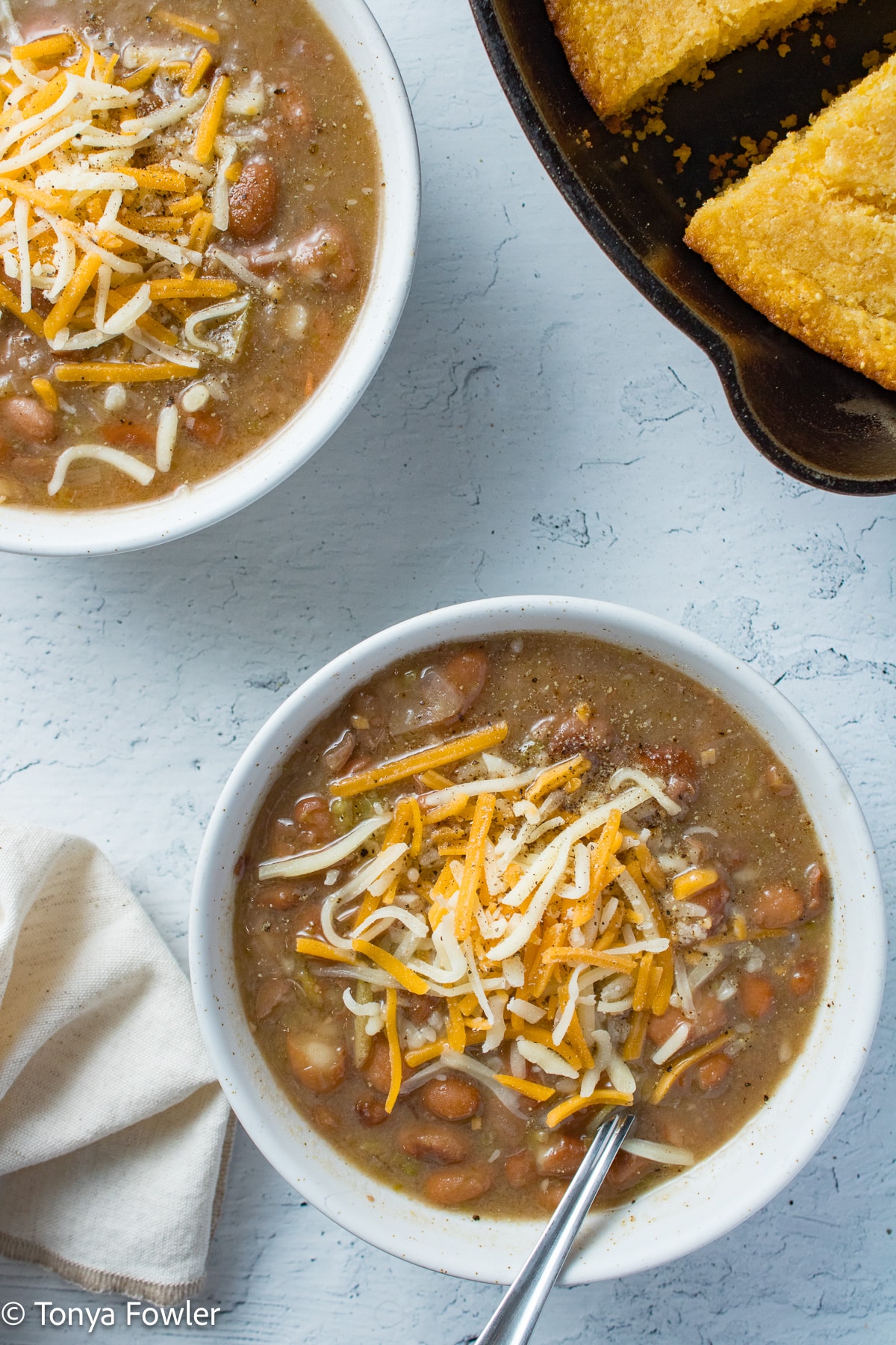 Beans with cheese on top in a bowl.