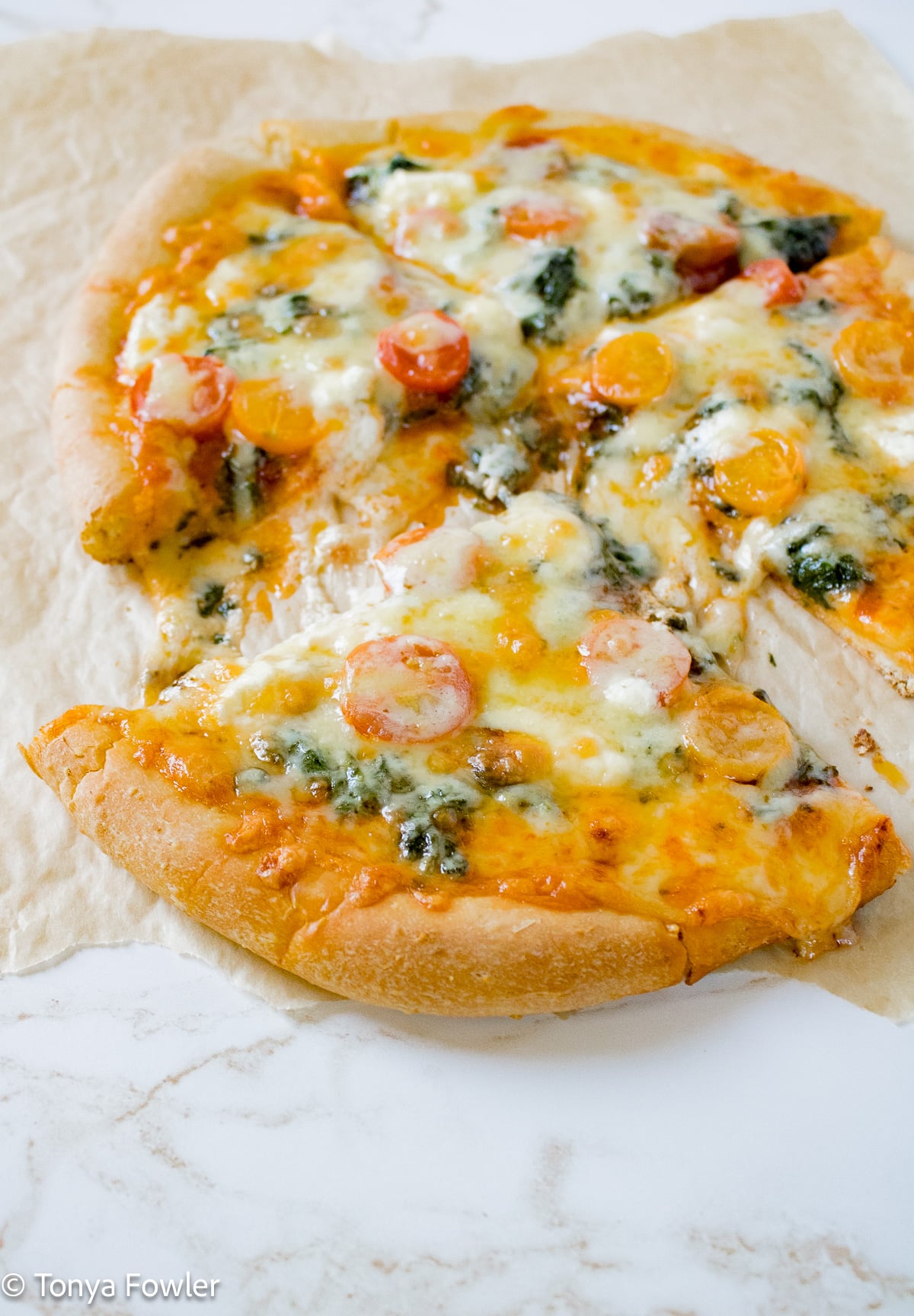 Spinach goat cheese pizza on cornmeal crust.
