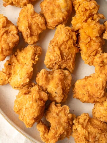 Close up image of fried chicken nuggets on a plate.
