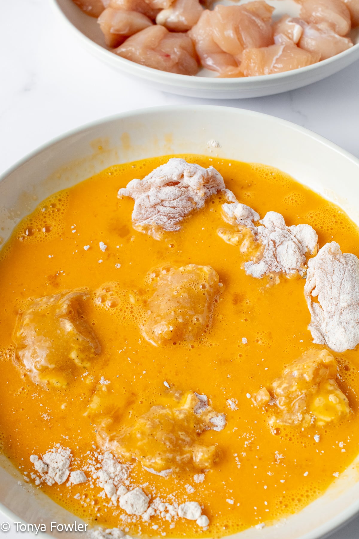 Chicken coated in flour and egg.