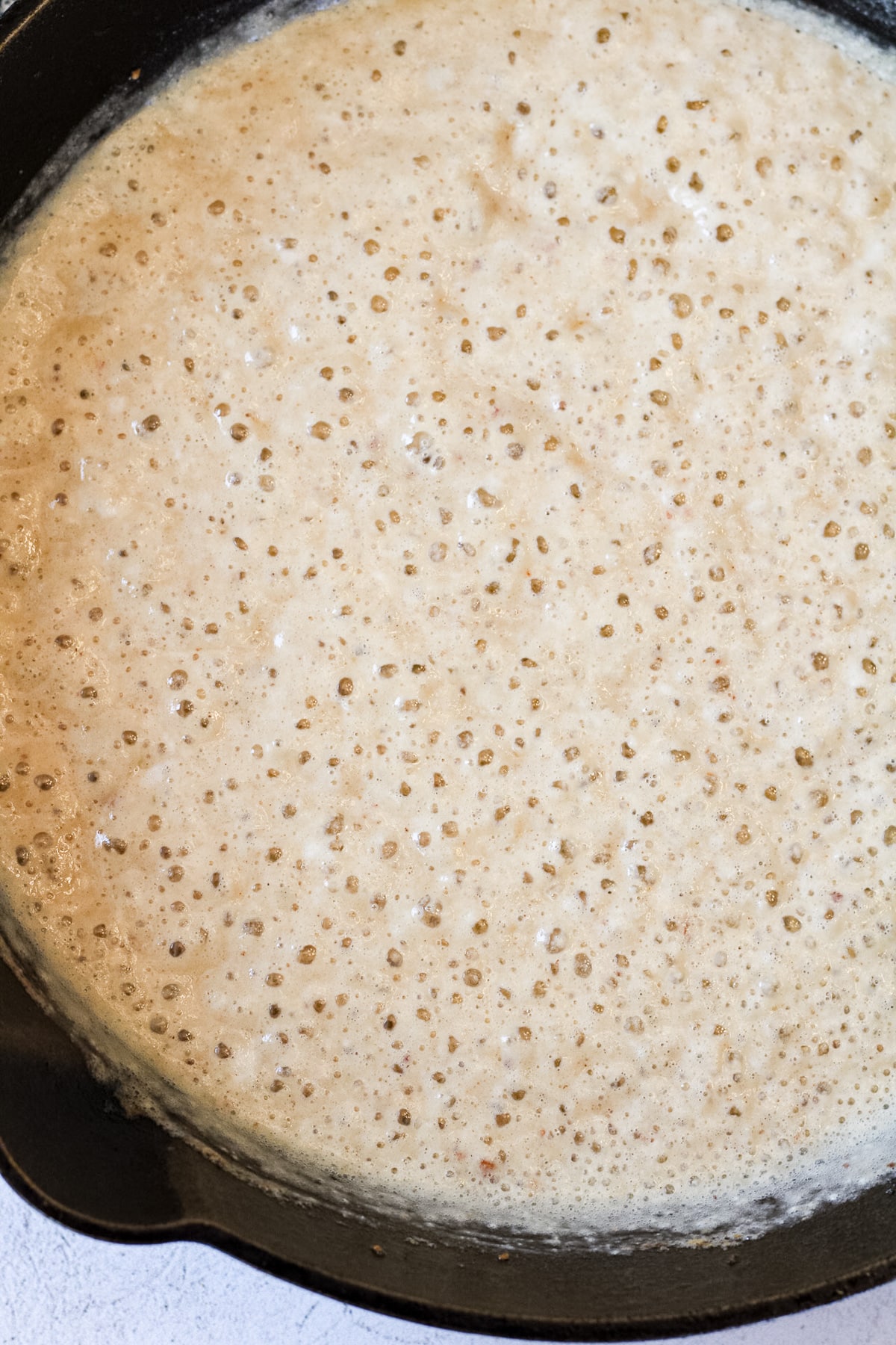 Overhead image of gravy in a cast iron skillet.