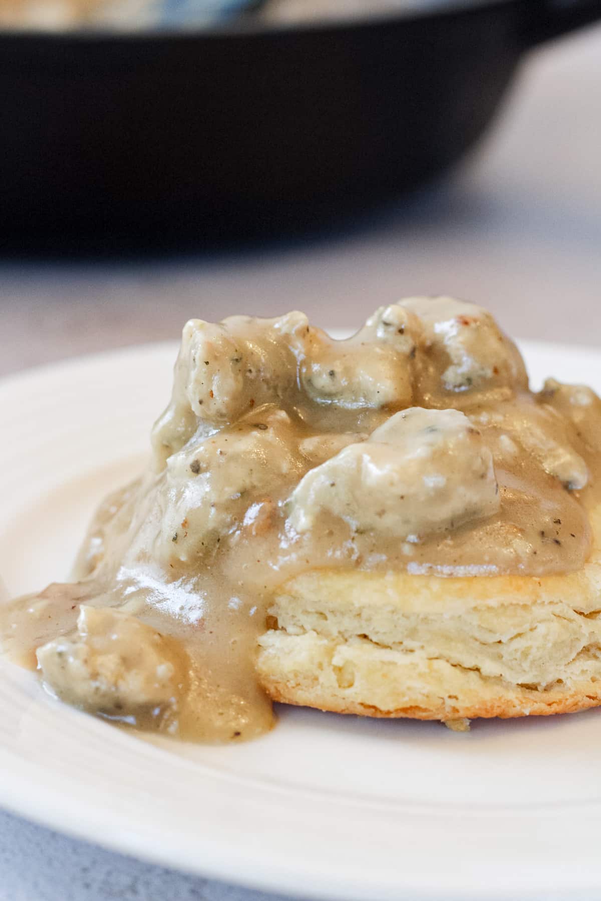 Close up image of chicken sausage gravy on a biscuit.