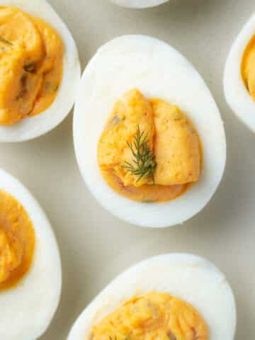 Close up image of deviled egg with dill on top.