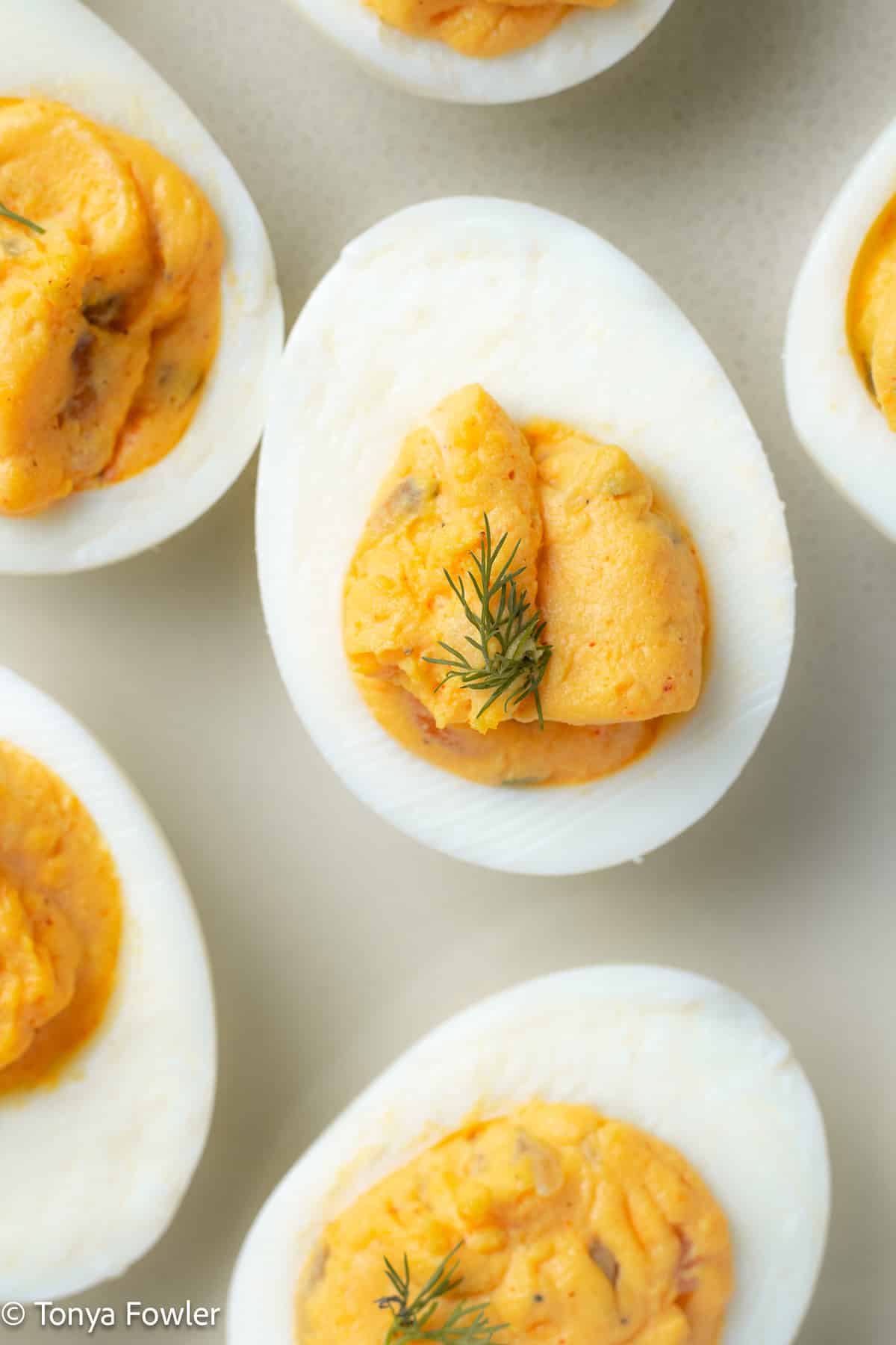 Close up image of deviled egg with dill on top.