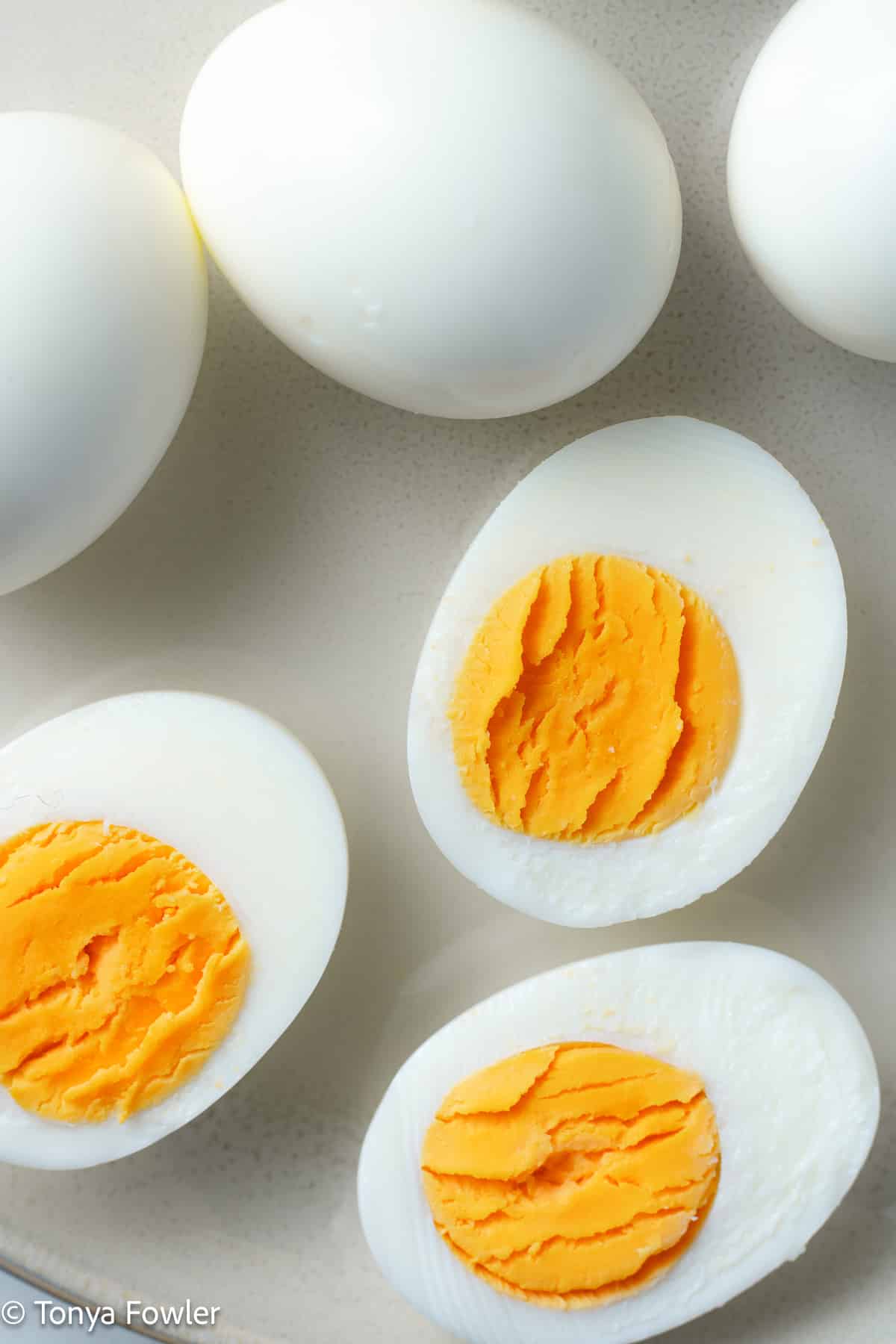 Hard boiled eggs sliced on a plate.