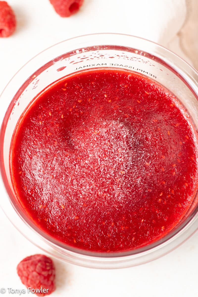 Frozen raspberry puree in a container. 