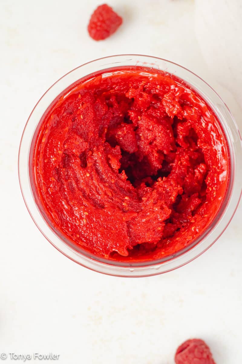 Blended raspberry sorbet in a container.