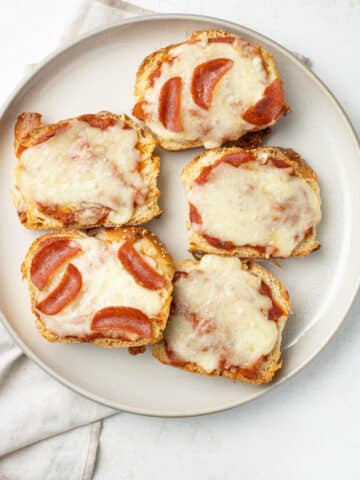 Overhead image of pizza toasts on a plate.