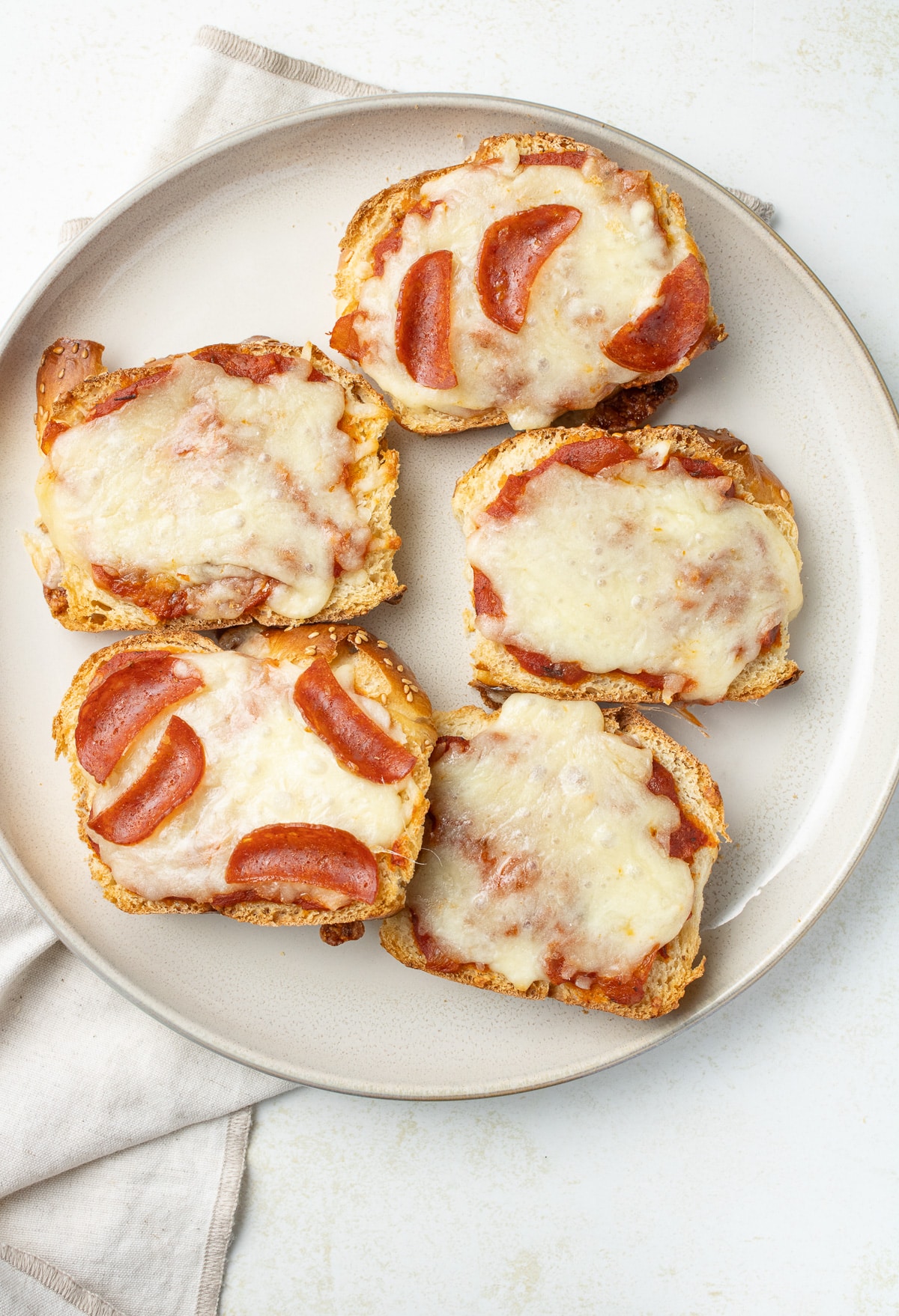 Overhead image of pizza toasts on a plate.