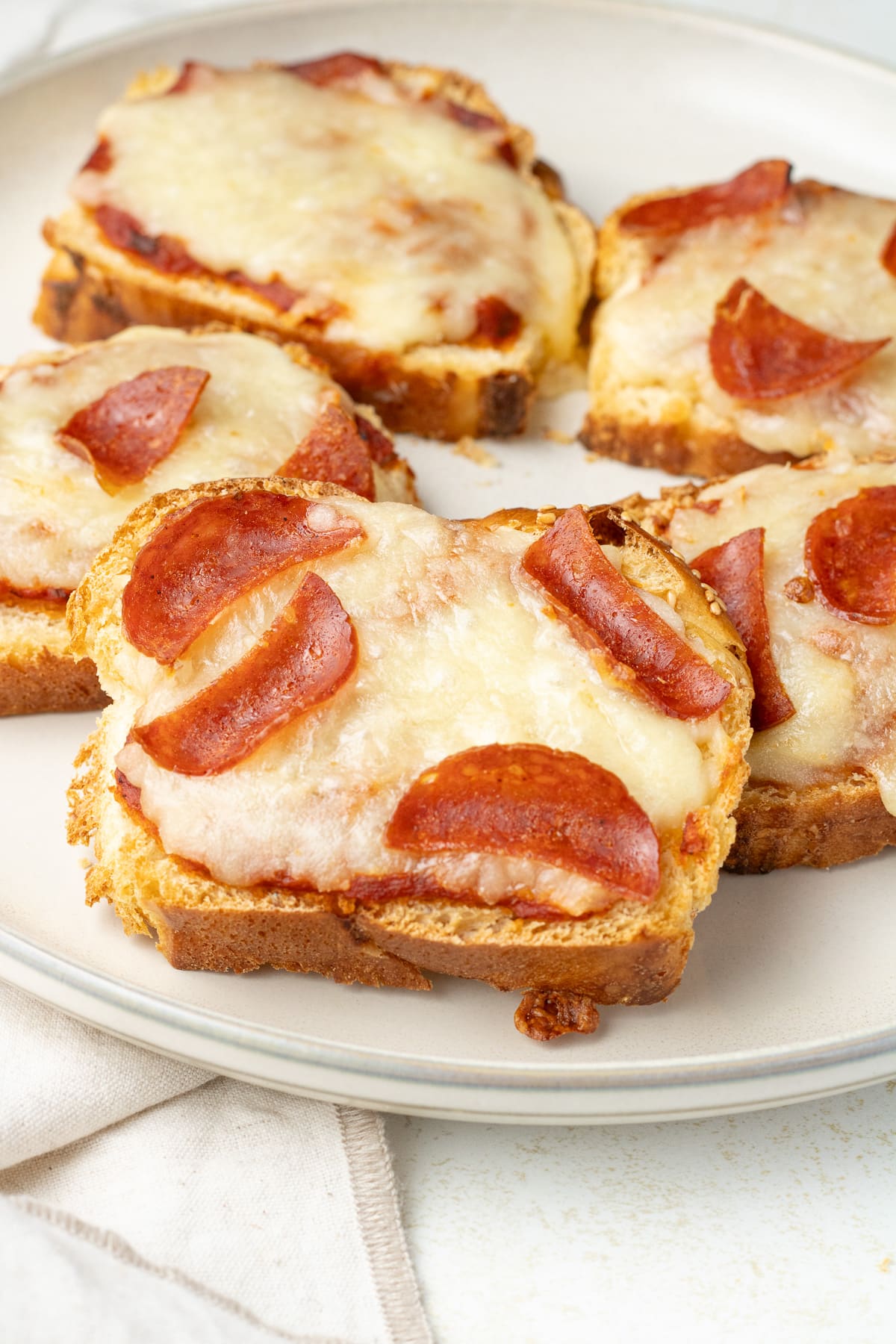 Close up image of pepperoni toasts on a plate.