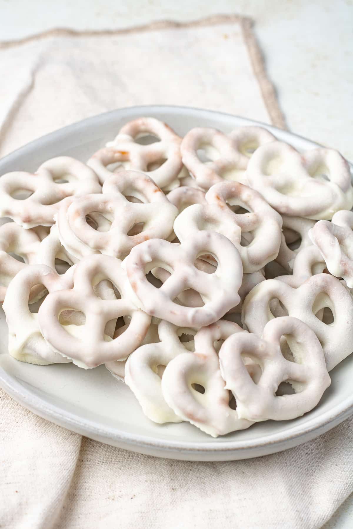 White chocolate pretzels on a plate.