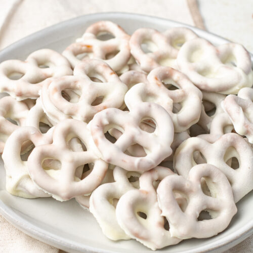 Side view of white chocolate pretzels on a plate.