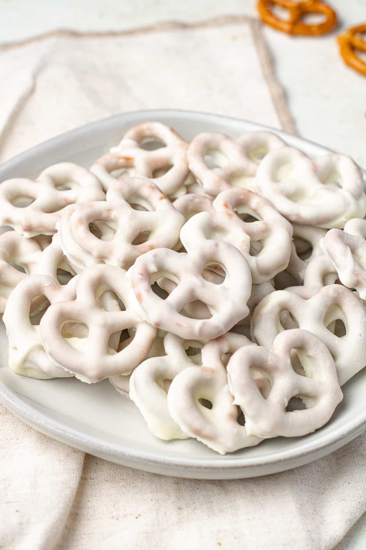 Side view of white chocolate pretzels on a plate.