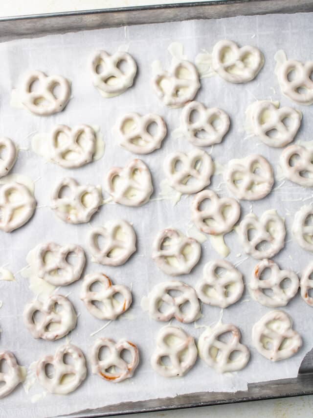 White chocolate covered pretzels on a sheet pan.