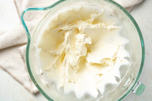 Whipped cream cheese in the bowl of a stand mixer.