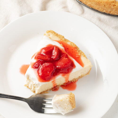 Close up image of cheesecake with strawberry sauce.