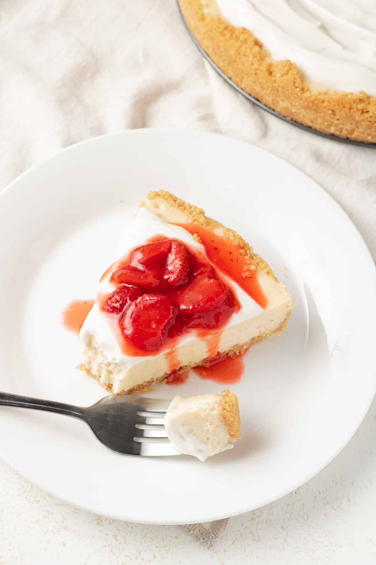 Close up image of cheesecake with strawberry sauce.
