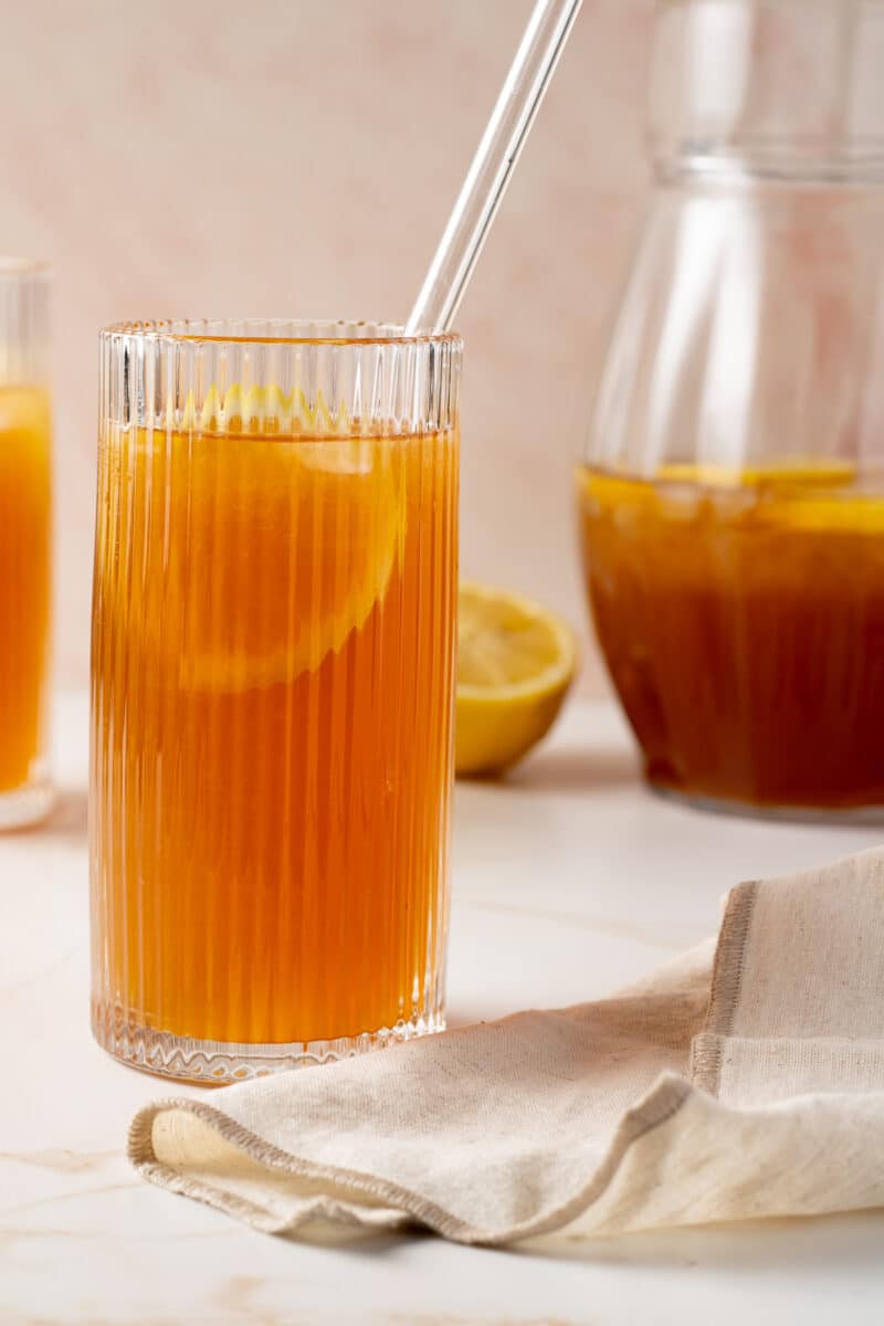 Close up image of iced tea lemonade in a glass with a lemon slice.