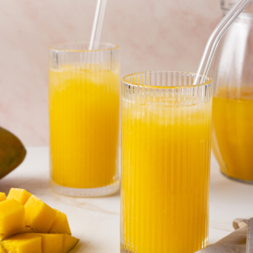 Mango lemonade in a glasses with a straw.