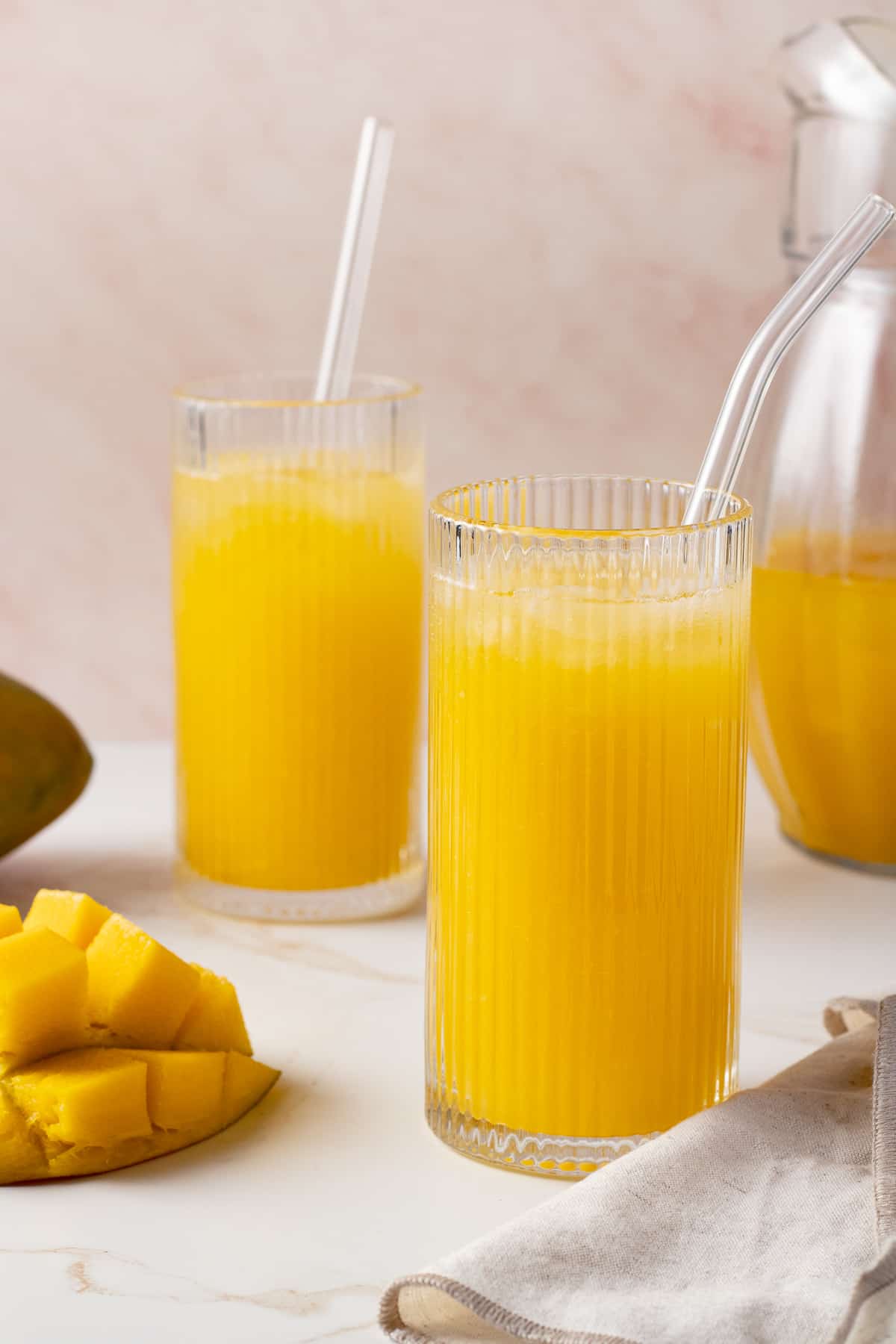 Mango lemonade in a glasses with a straw.
