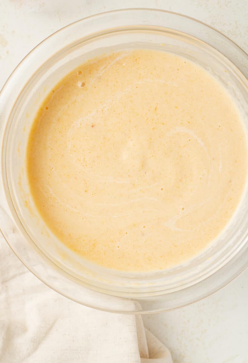 Peach puree mixed with cream in a bowl.