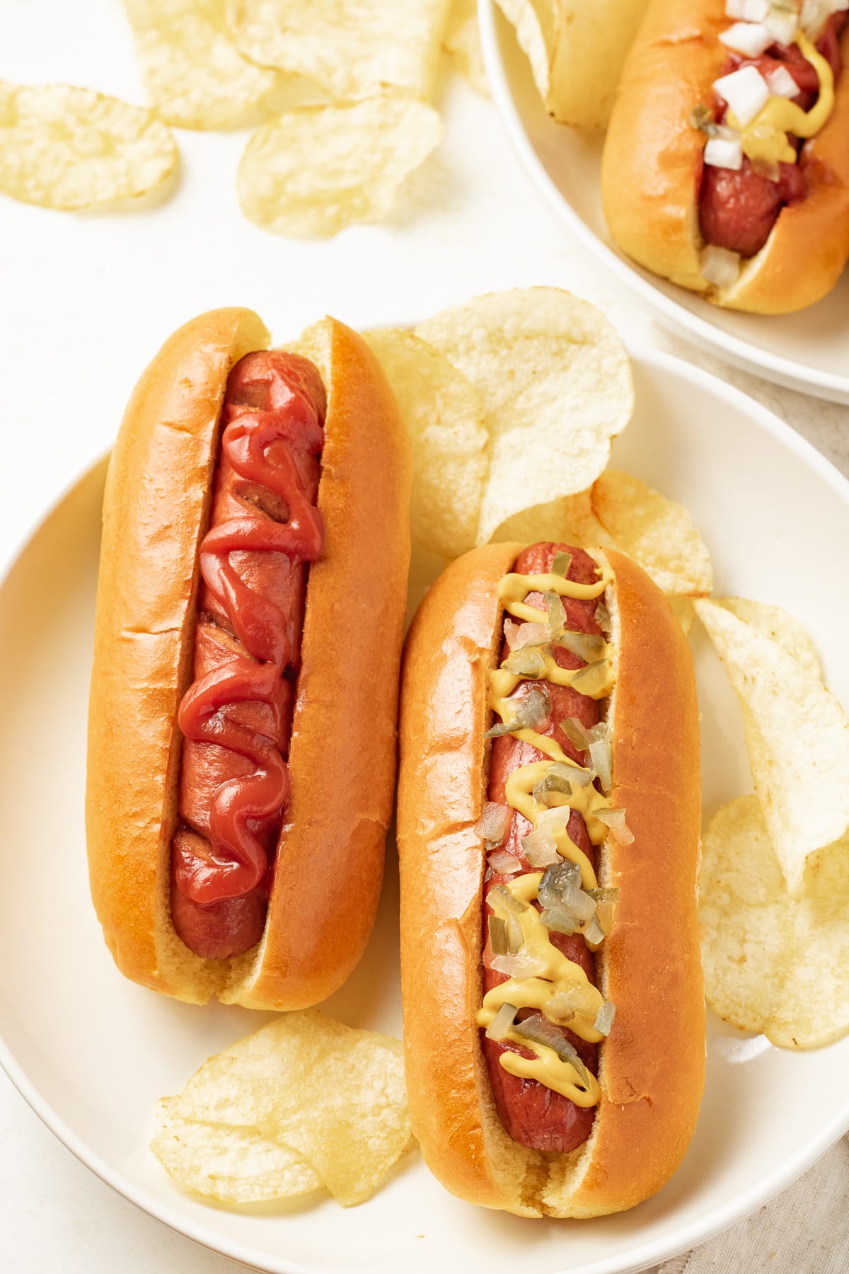 Hot dogs with toppings on a plate.