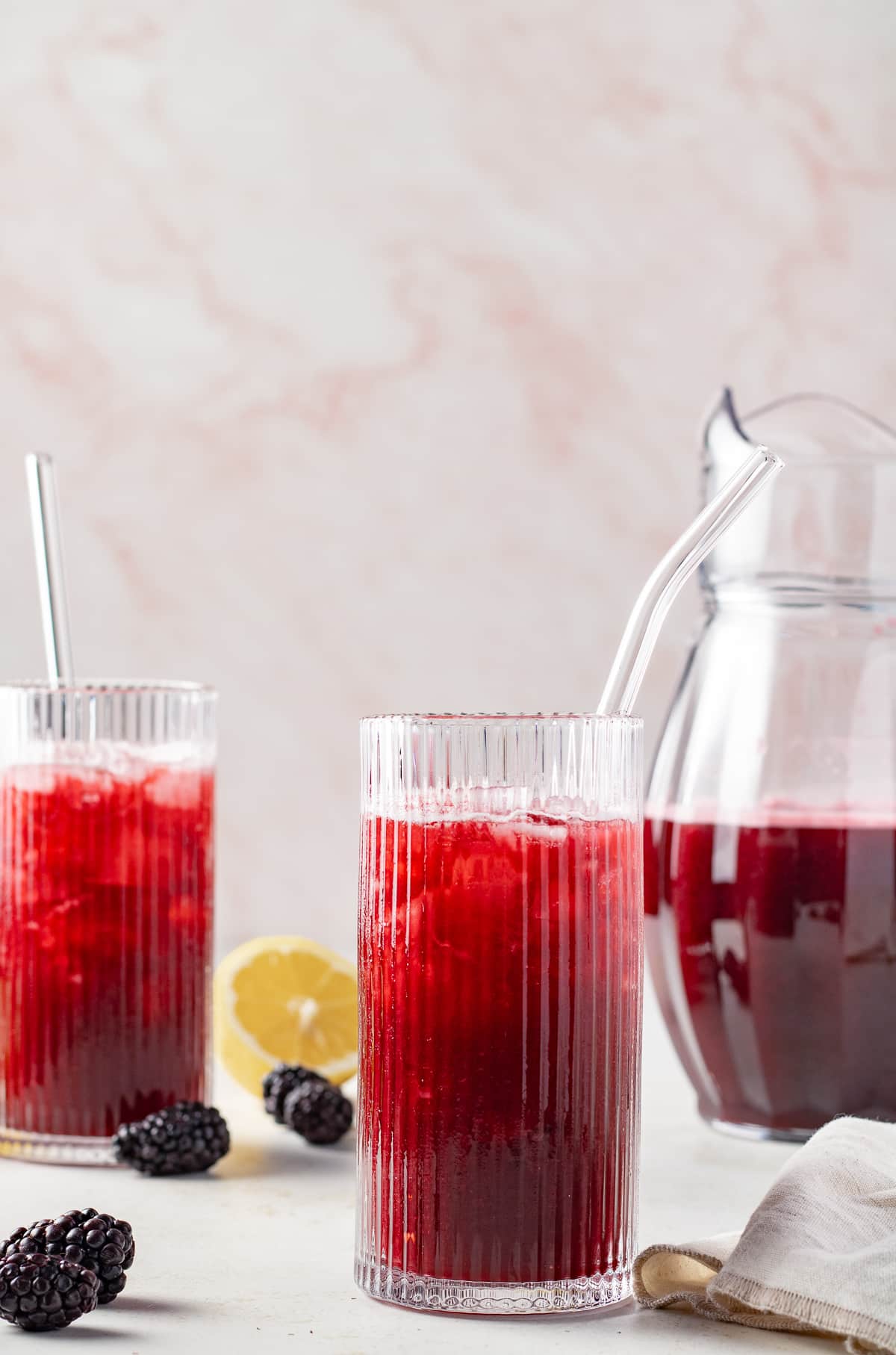 Blackberry lemonade in glasses with fresh fruit on the table.