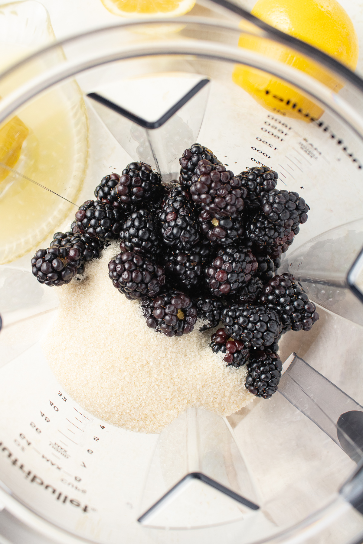 Fresh blackberries and sugar in a blender.
