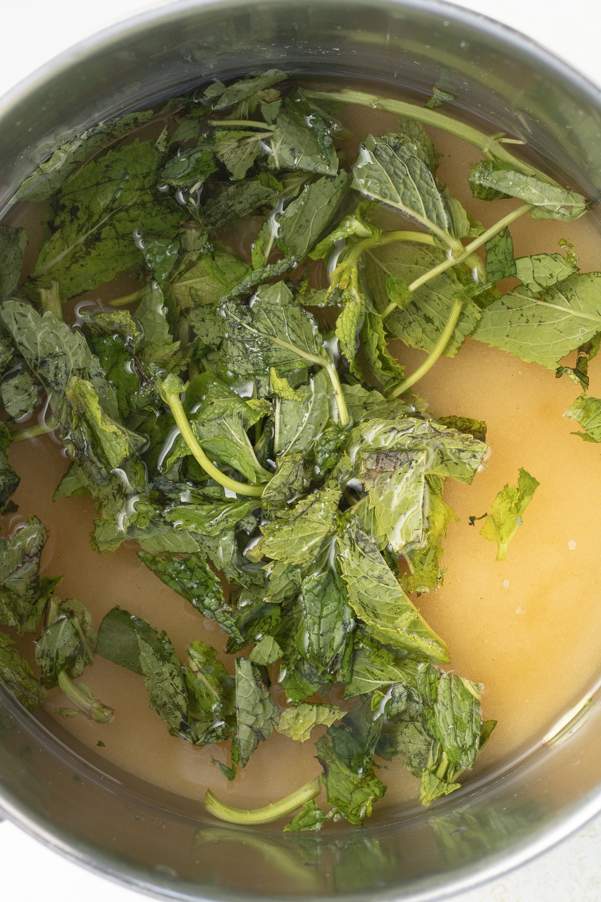 Fresh mint leaves and cane sugar in a pot.