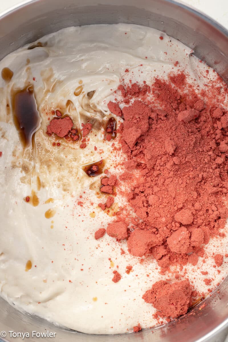 Melted marshmallows in a pot with vanilla extract and crushed freeze-dried strawberries on top.