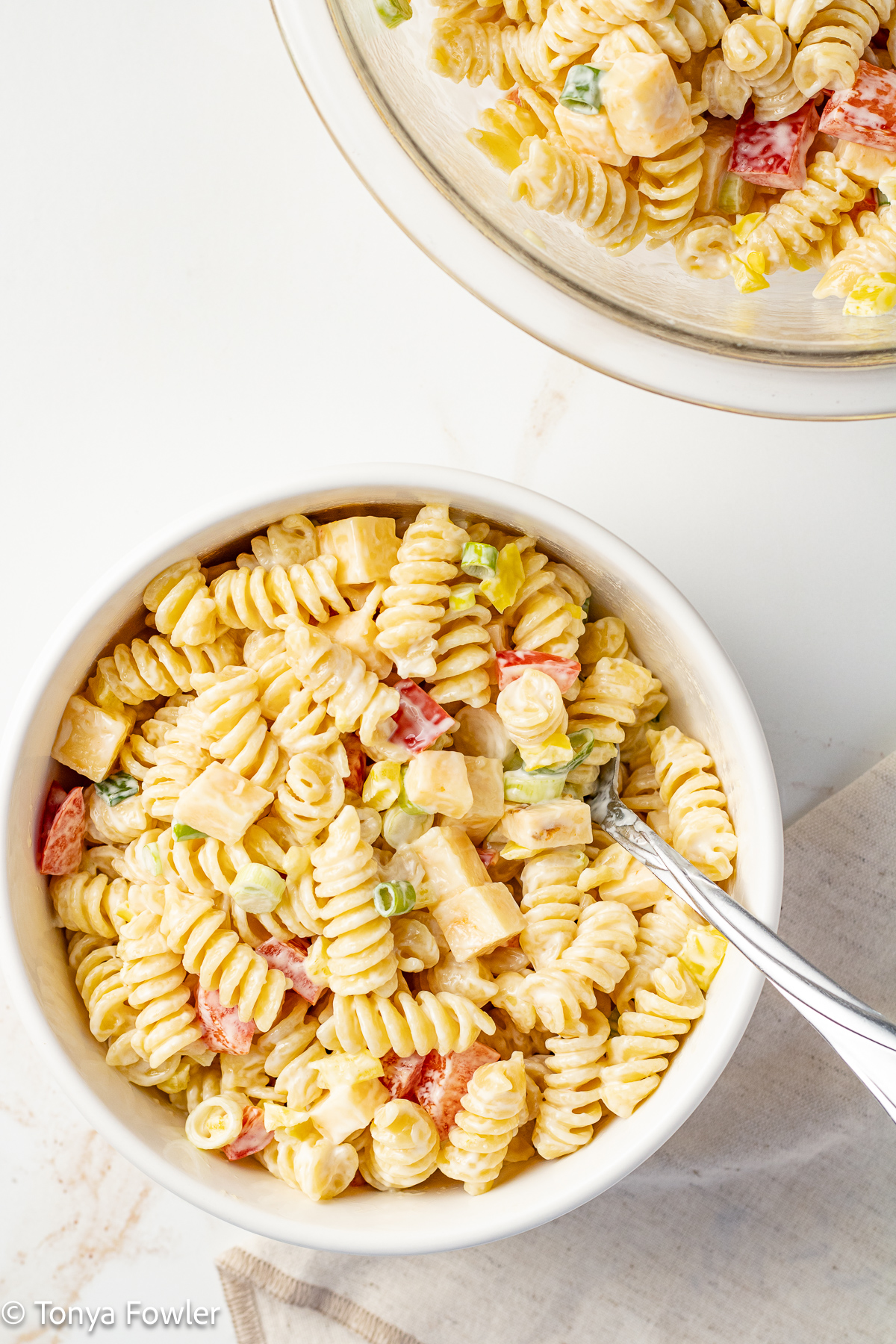 Pasta salad in a bowl with a spoon.