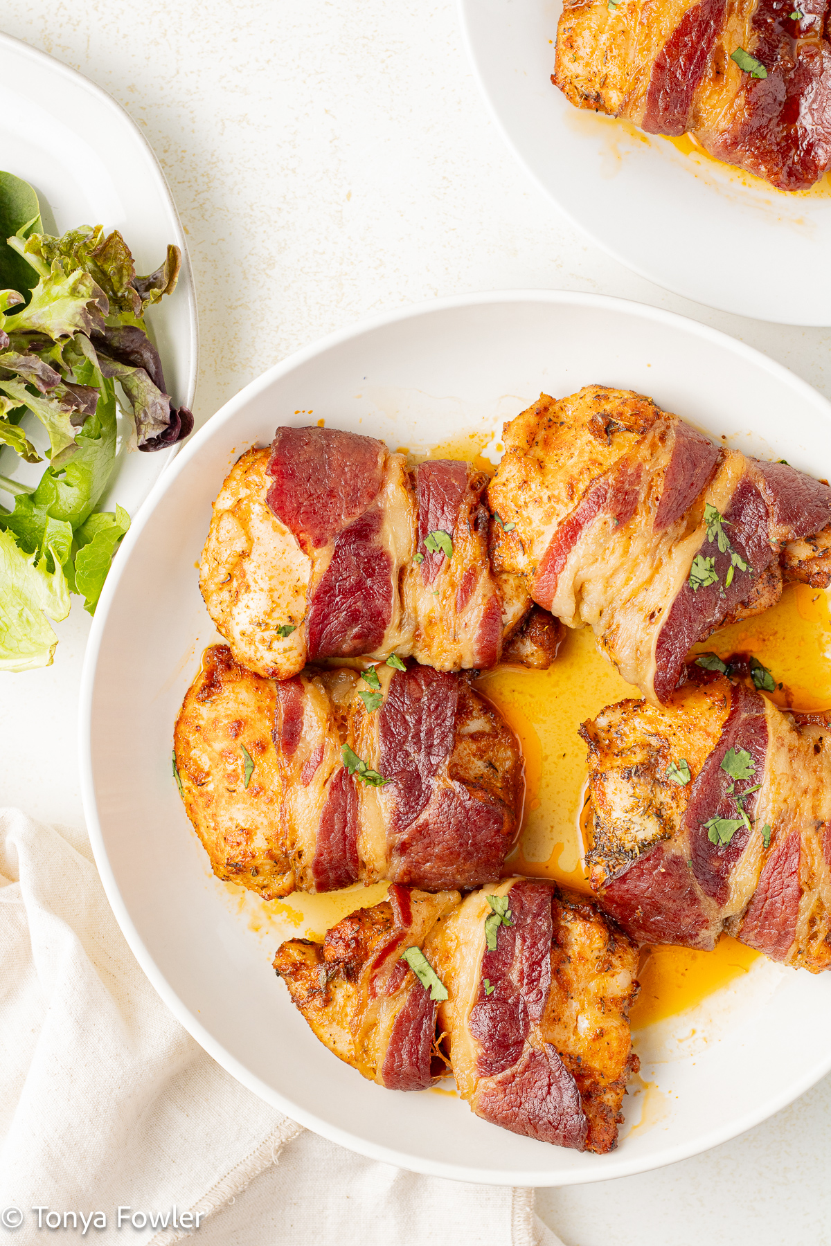 Bacon wrapped chicken thighs on a plate.