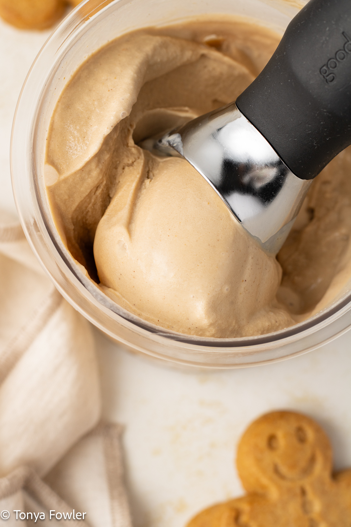 Overhead view of a scoop of ice cream in a container with a ice cream scoop.