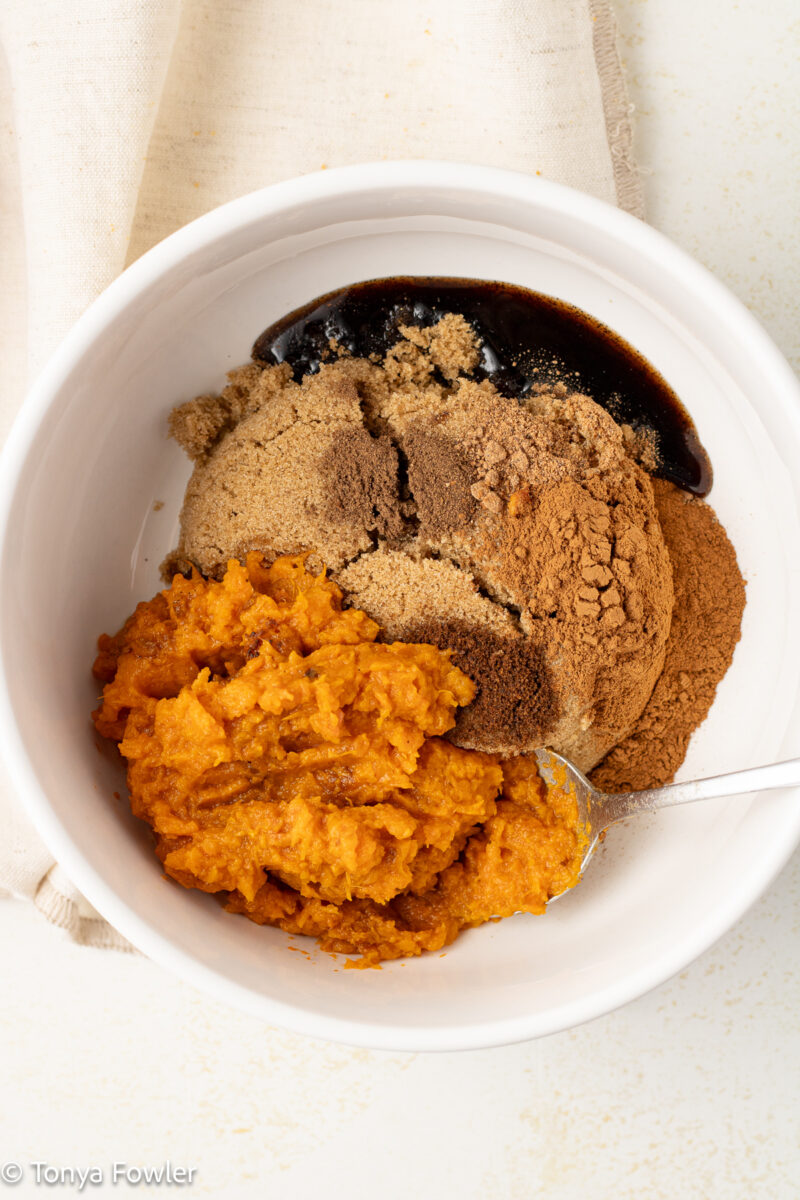 Mashed sweet potato, sugar and spices in a bowl. 