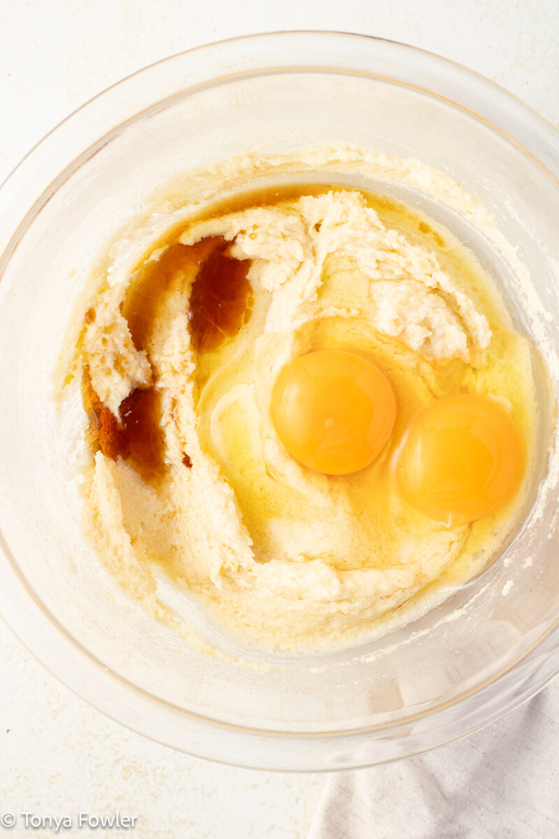 Creamed butter and sugar in a bowl with eggs and vanilla extract. 