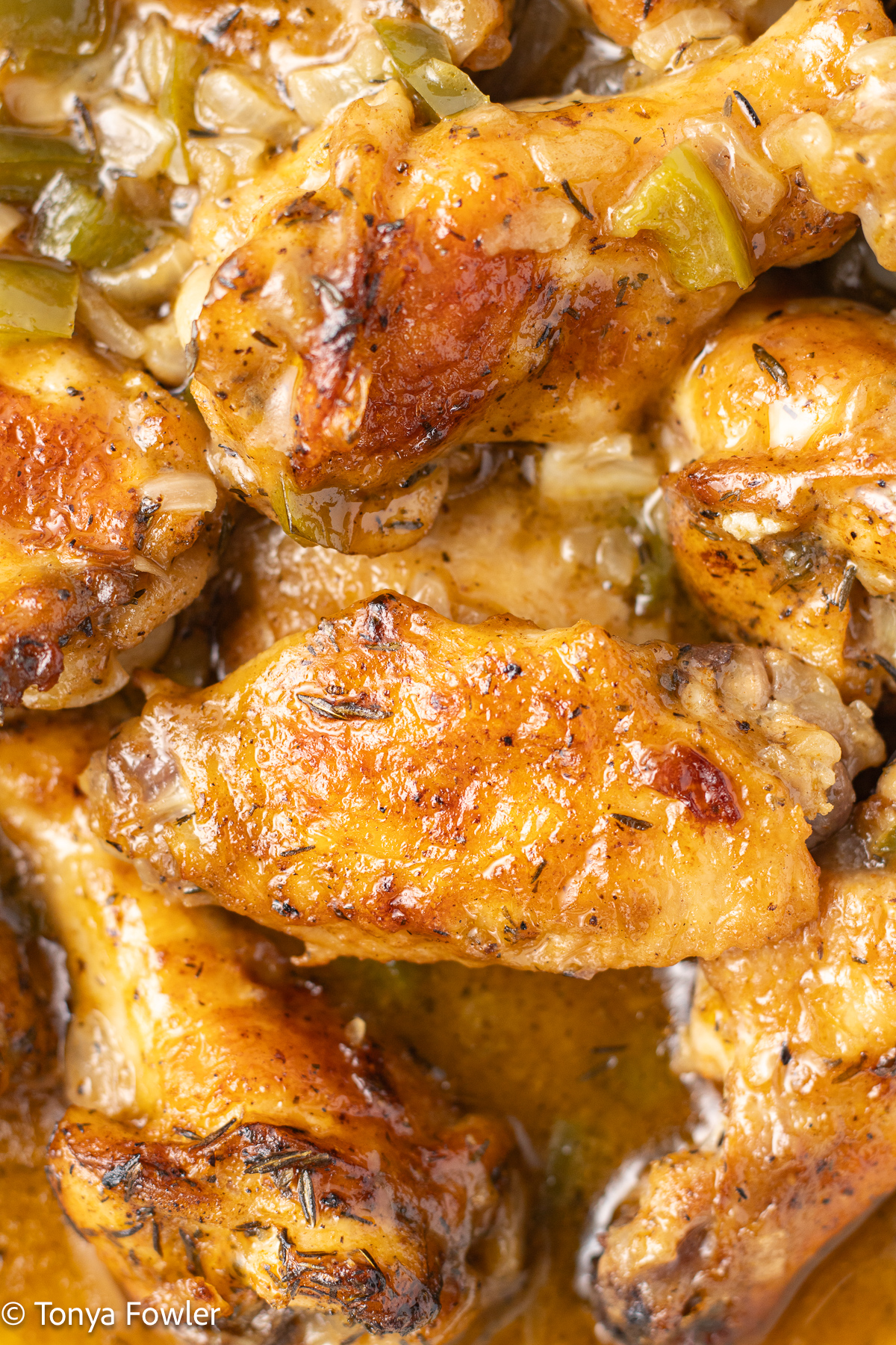 Close up image of smothered chicken wings. 