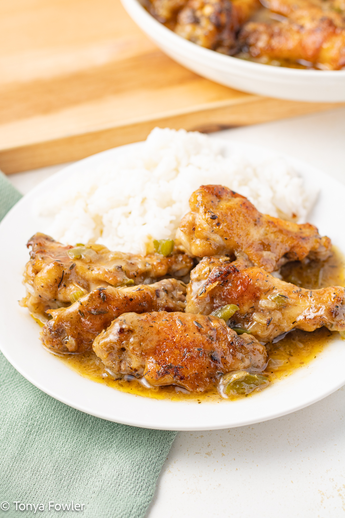 Chicken wings on a plate with rice and gravy.