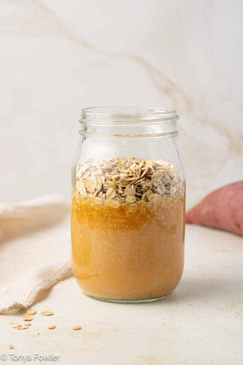 Sweet potato puree in a mason jar topped with rolled oats.