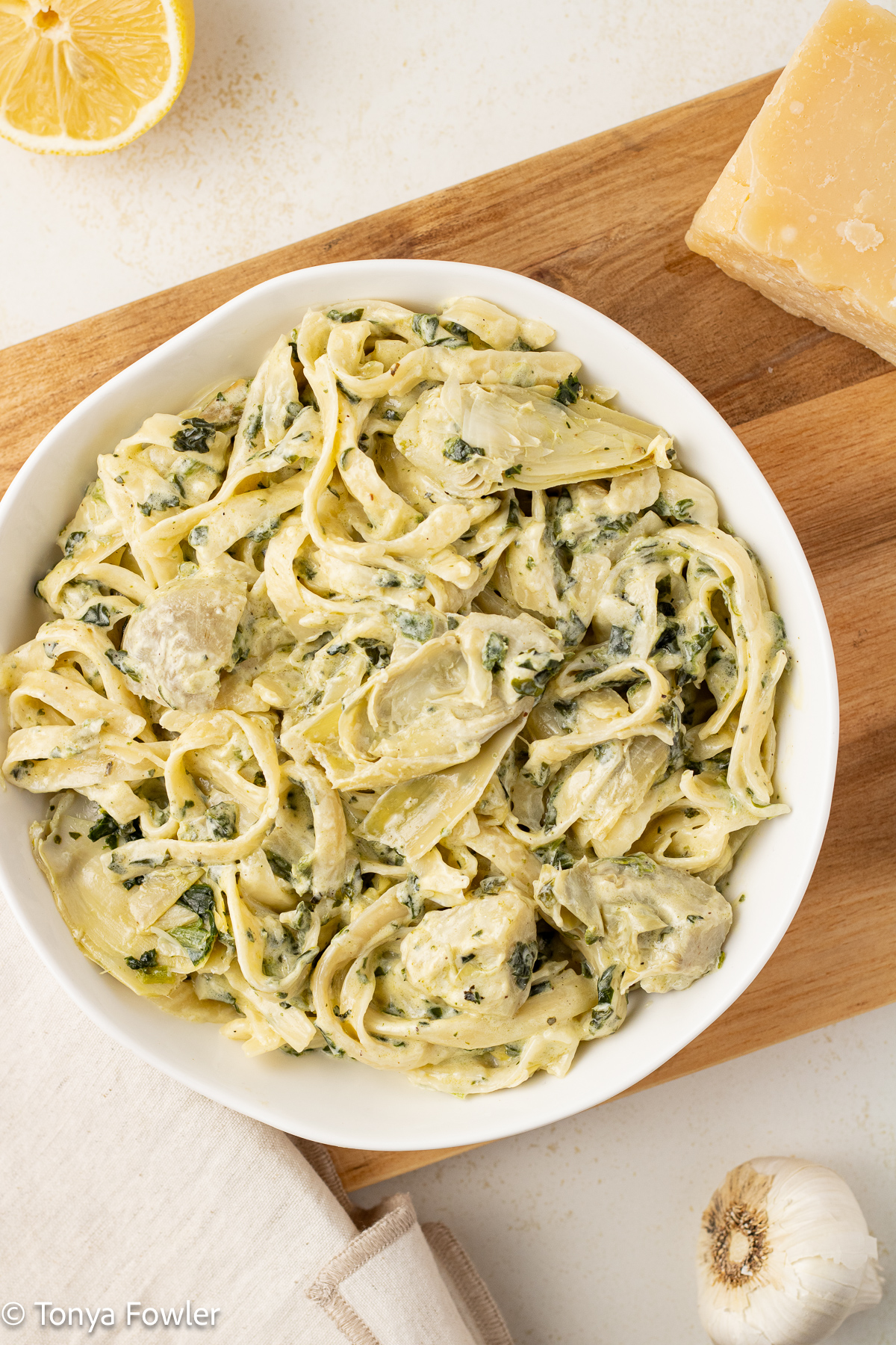 Overhead image of spinach artichoke pasta in a bowl. 