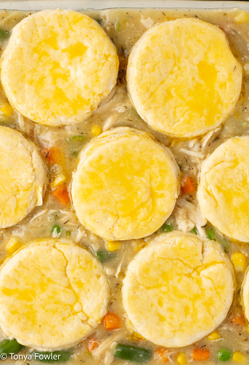 Biscuit dough brushed with egg wash on top of pot pie filling.