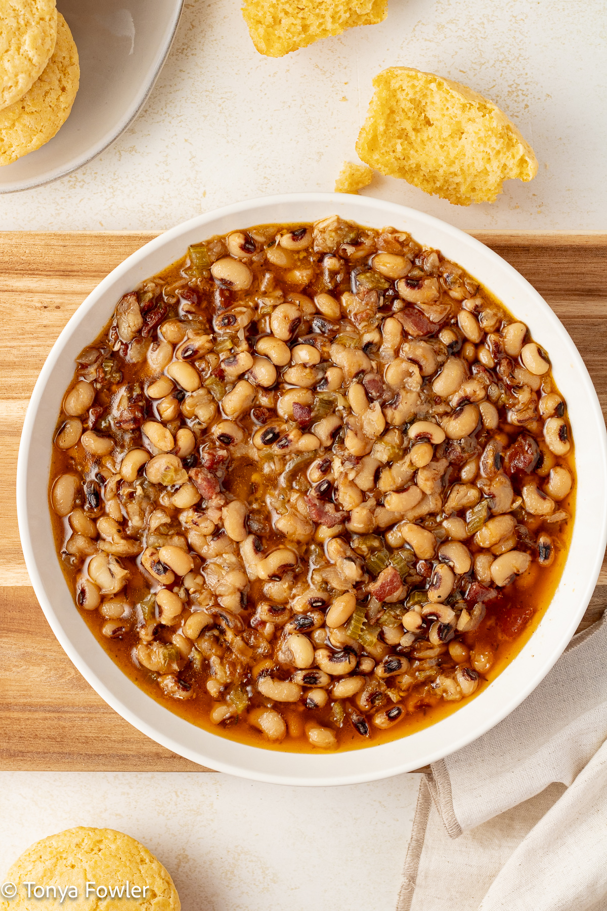 Instant Pot Black Eyed Peas in a bowl with cornbread muffins all around.