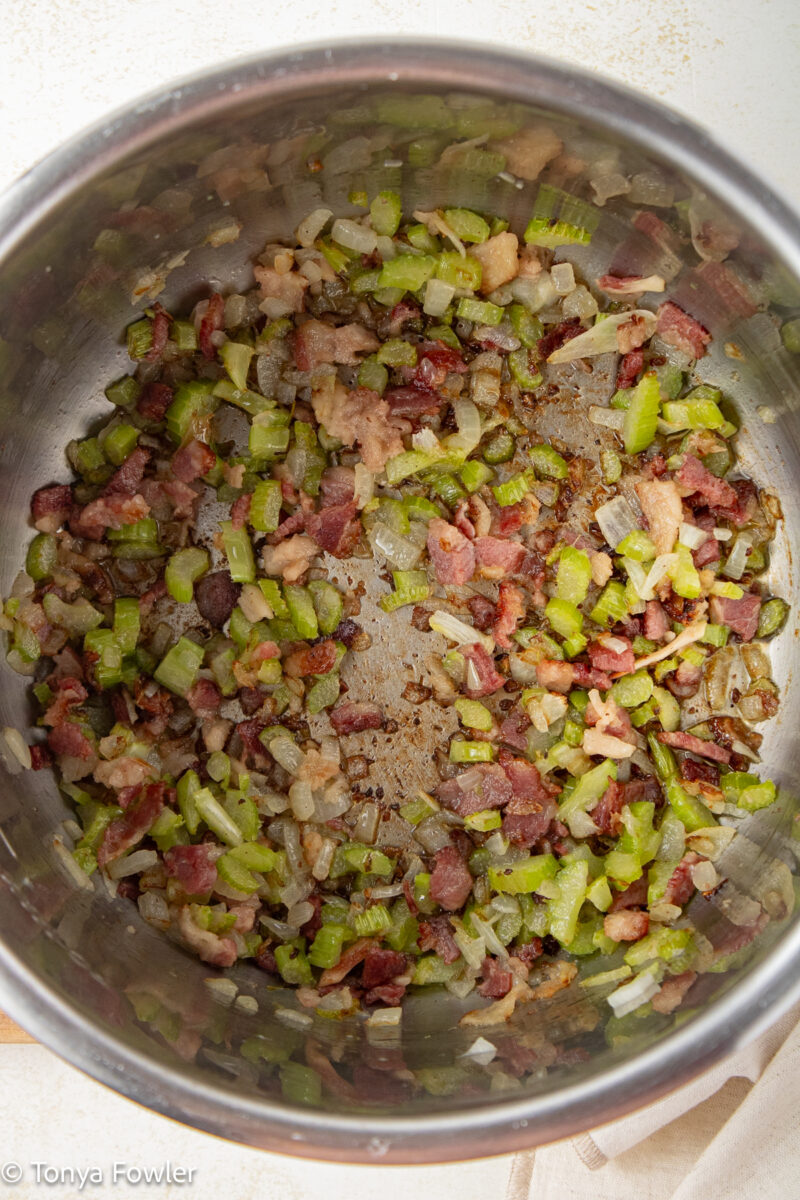 Cooked bacon and vegetables in a pot.