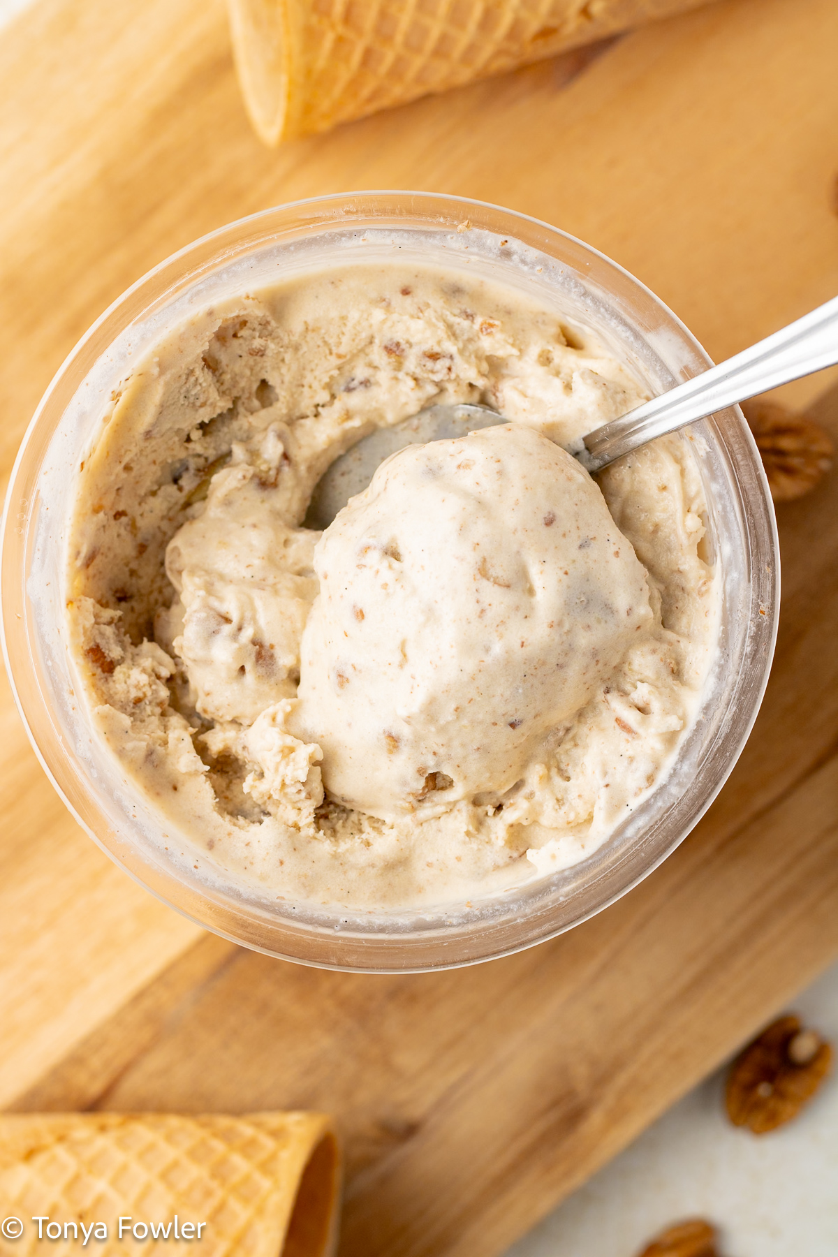 Close up image of ninja creami butter pecan ice cream in a container with a spoon.