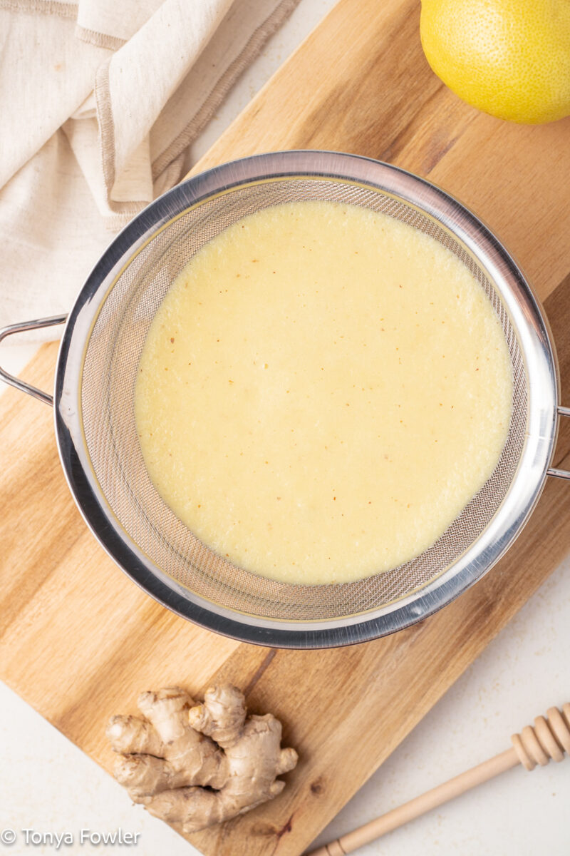 Blended lemon and ginger in a strainer.