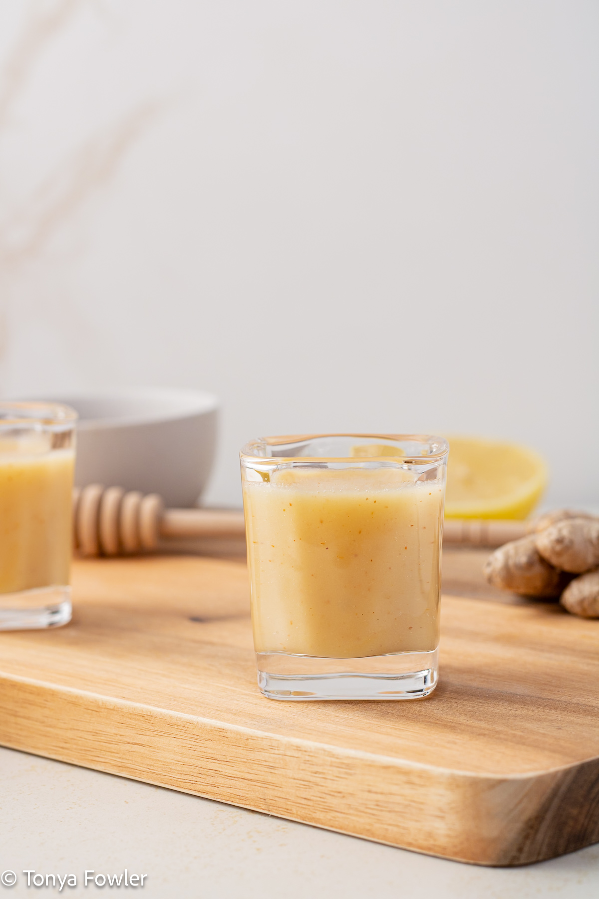 Straight on view of Cayenne Lemon Ginger Shots on a cutting board.