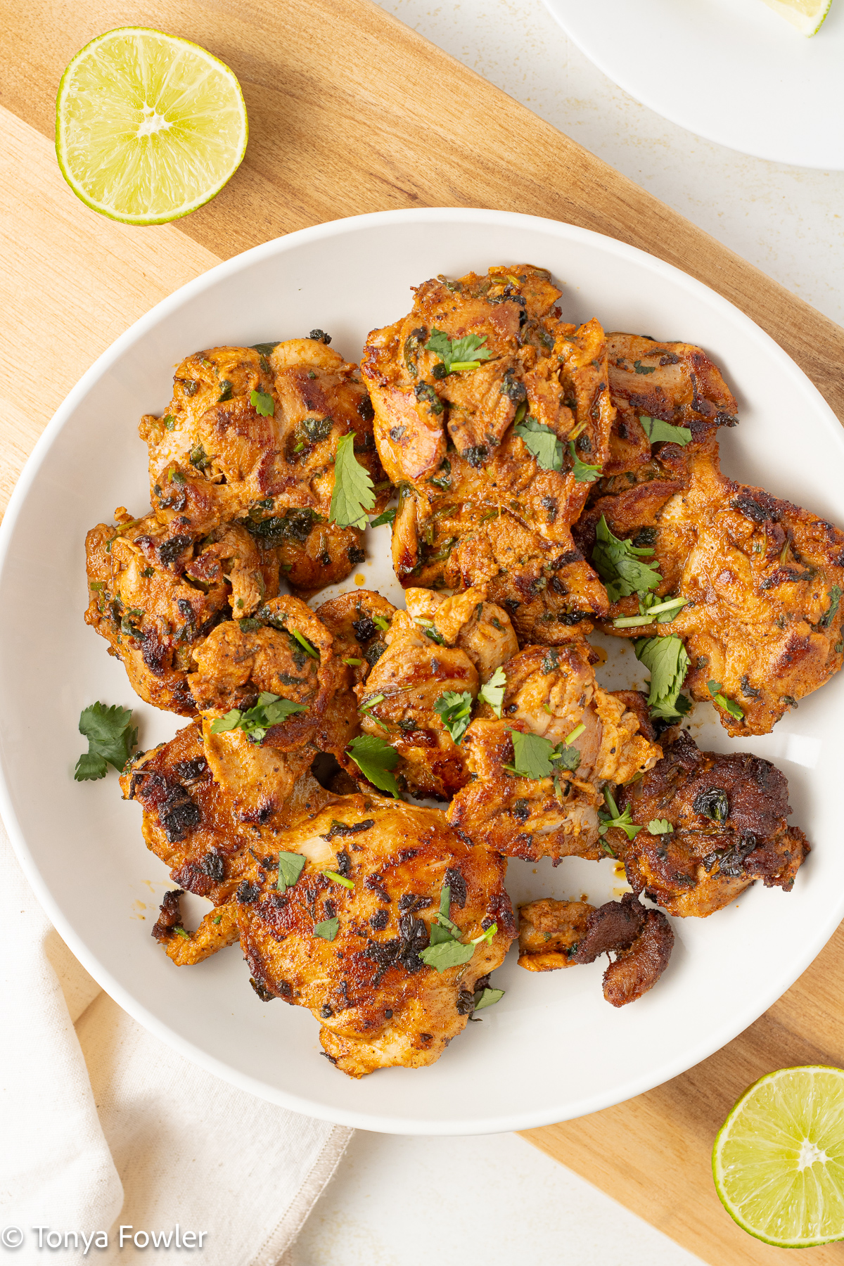 Overhead view of cilantro lime chicken with lime slices all around. 