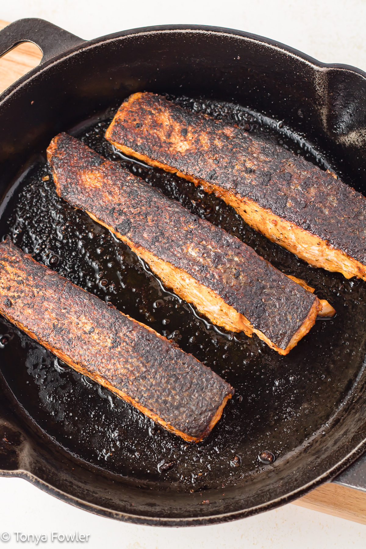 Cooked salmon fillets in a cast iron skillet. 