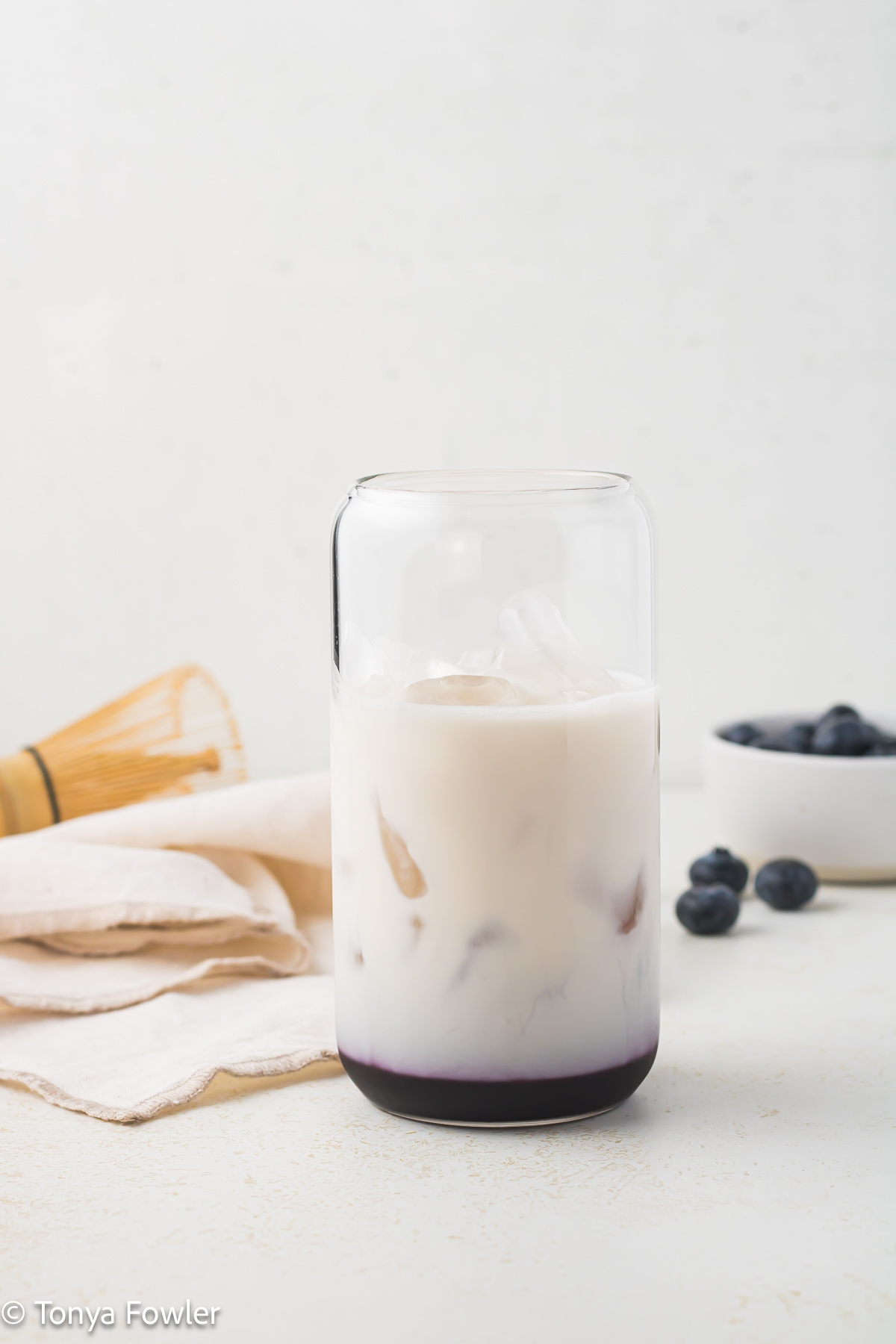 Milk and blueberry syrup in a glass.