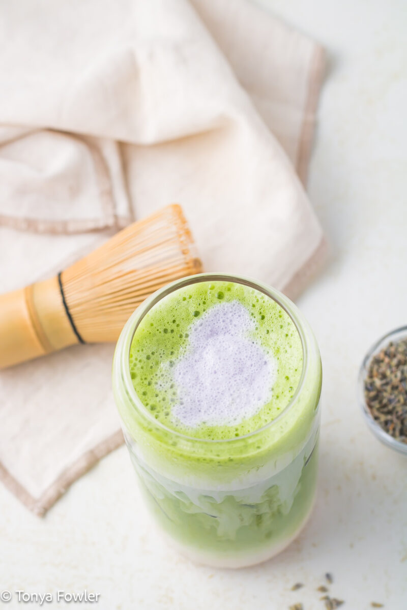 3/4 view of a matcha latte topped with lavender cold foam.
